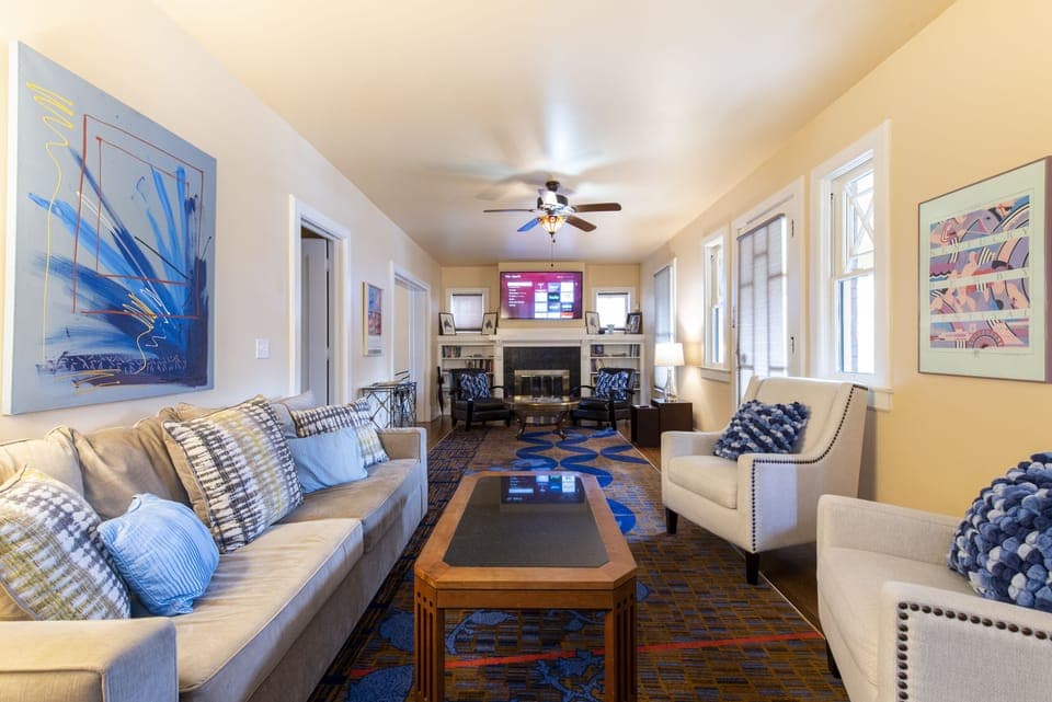 Livingroom with dual seating areas, 65" smart tv and queen sleeper sofa.
