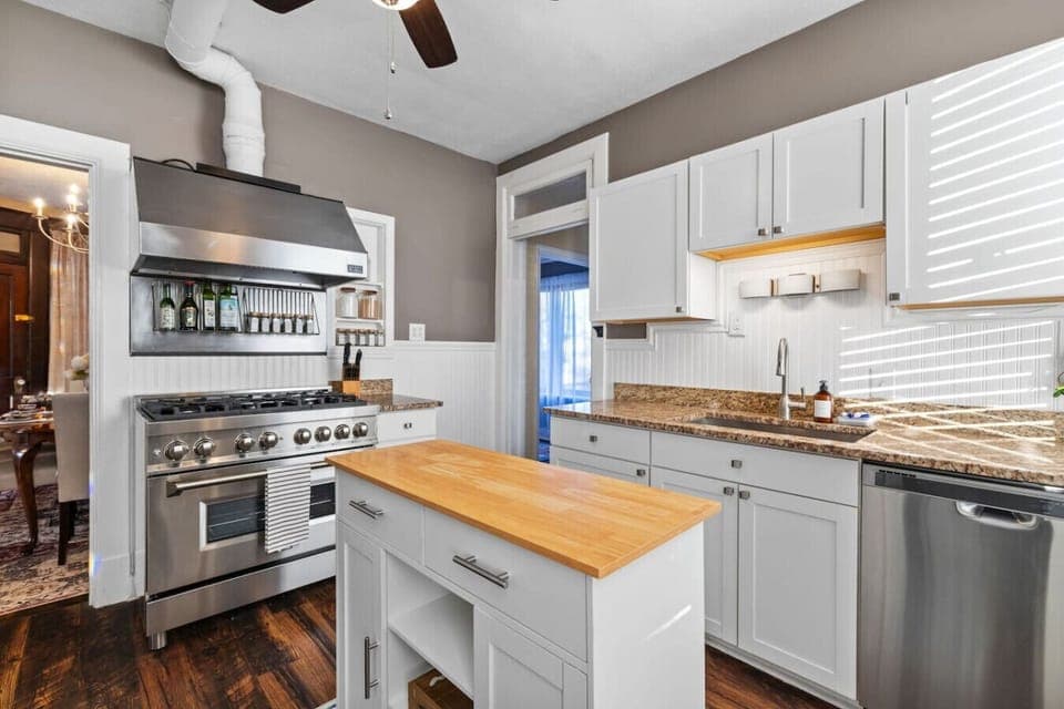 Clean, Classic, and Ready for You – Fresh white cabinetry, granite counters, and a rolling island provide everything you need to prep meals or just sip coffee in style.