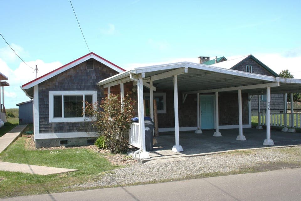 The front of the cottage, showing ample uncover parking for two cars and bikes.