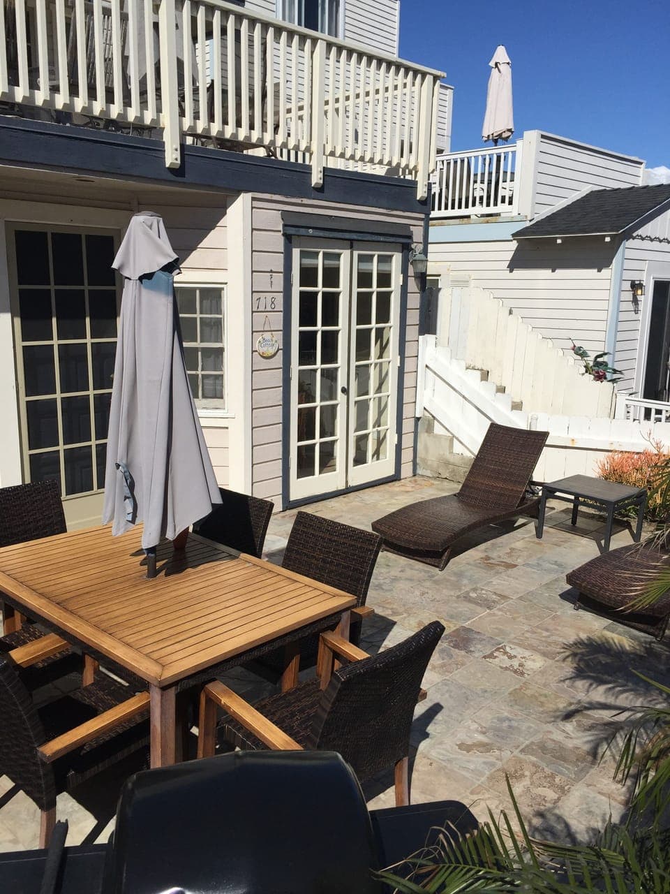 Private patio with umbrella table, six chairs, two lounge chairs and grill.