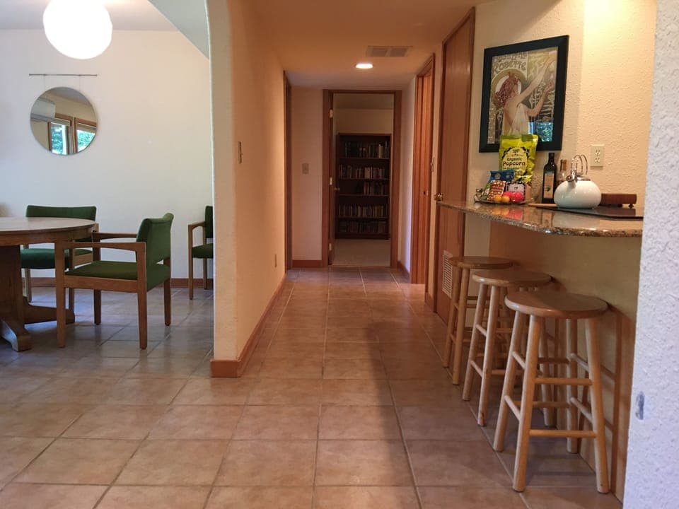 Hallway from open floor plan living area leading to bathroom and two bedrooms.