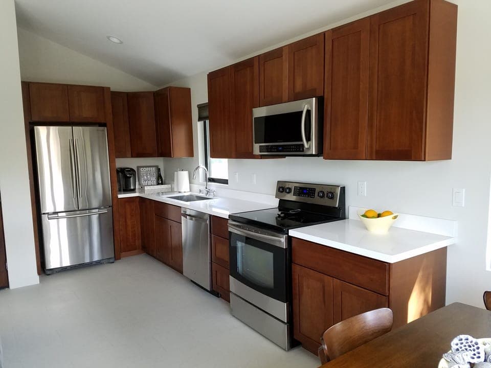 Chef's kitchen with full size stainless steel appliances and quartz countertop