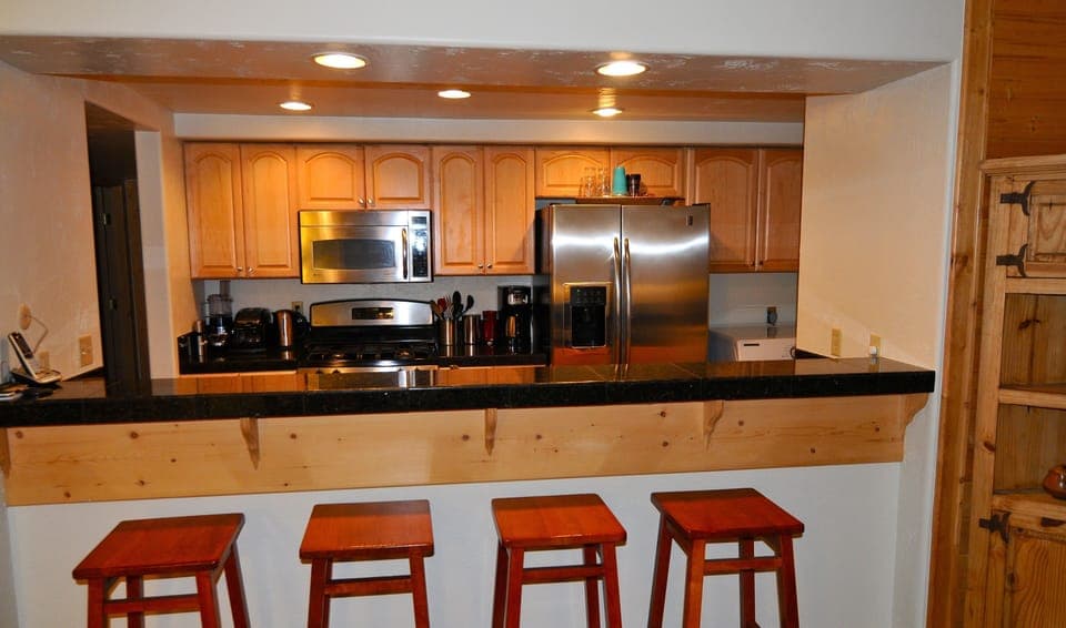 Breakfast bar counter by kitchen is great for quick meals or as a serving area