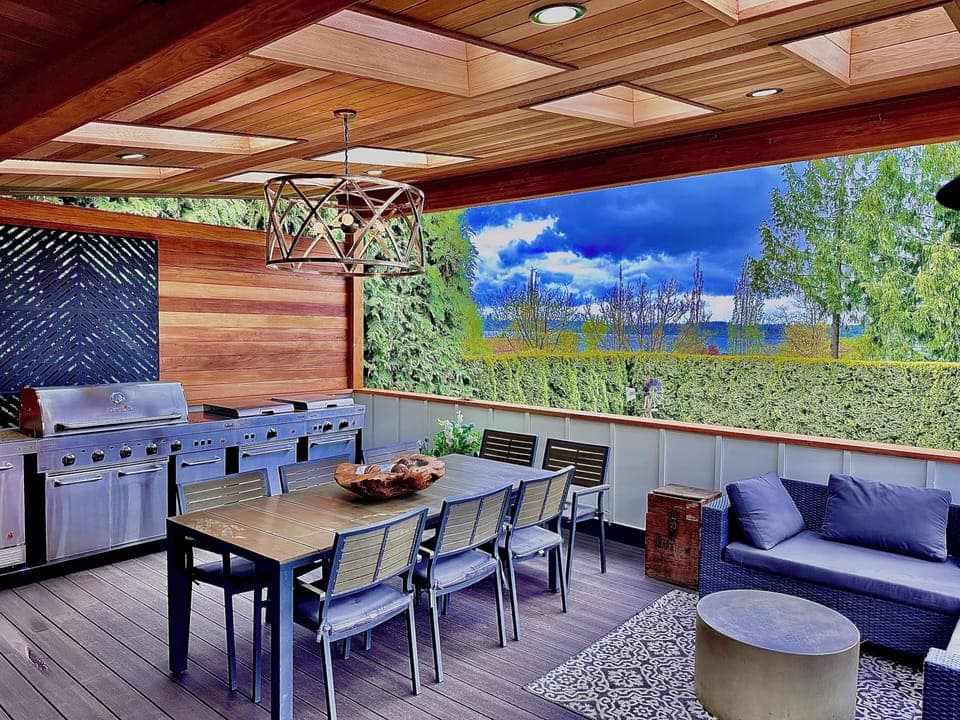 Expansive covered back deck with lounge area, skylights and five piece bbq grill