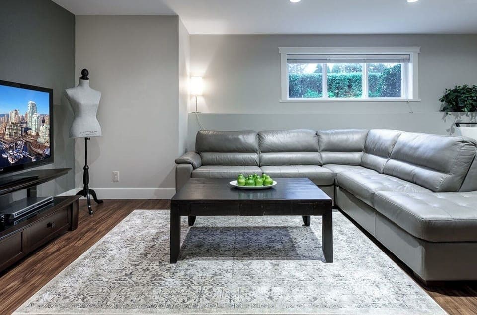 Living area with 50" TV, large leather sectional couch & convertible double bed.