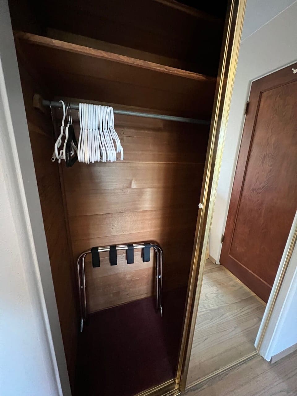 Double mirror Cedar closet in guest room with luggage rack and lots of hangers.