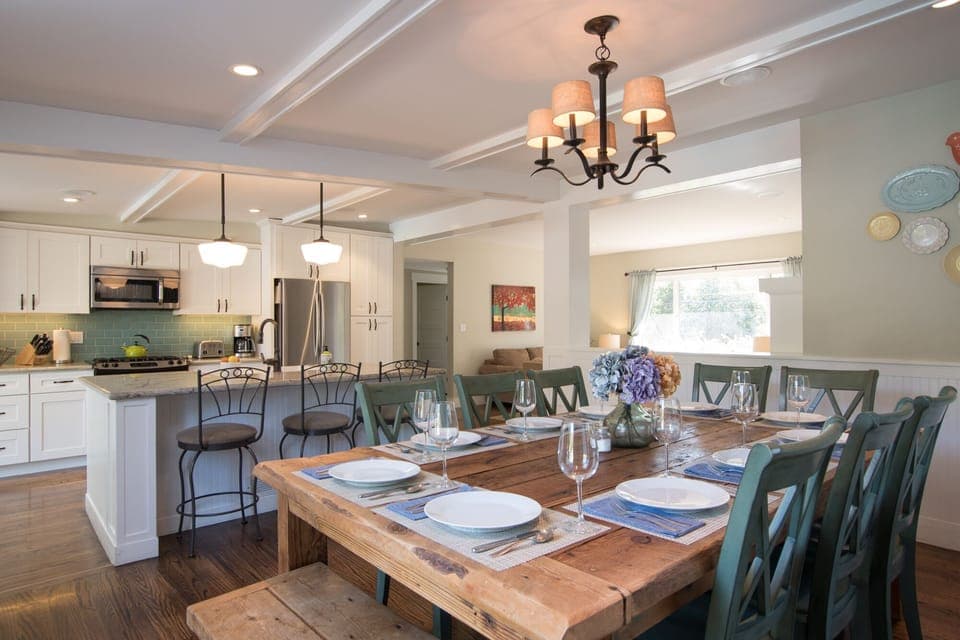 Open plan kitchen with large island and 3  bar seats adjacent to dining area