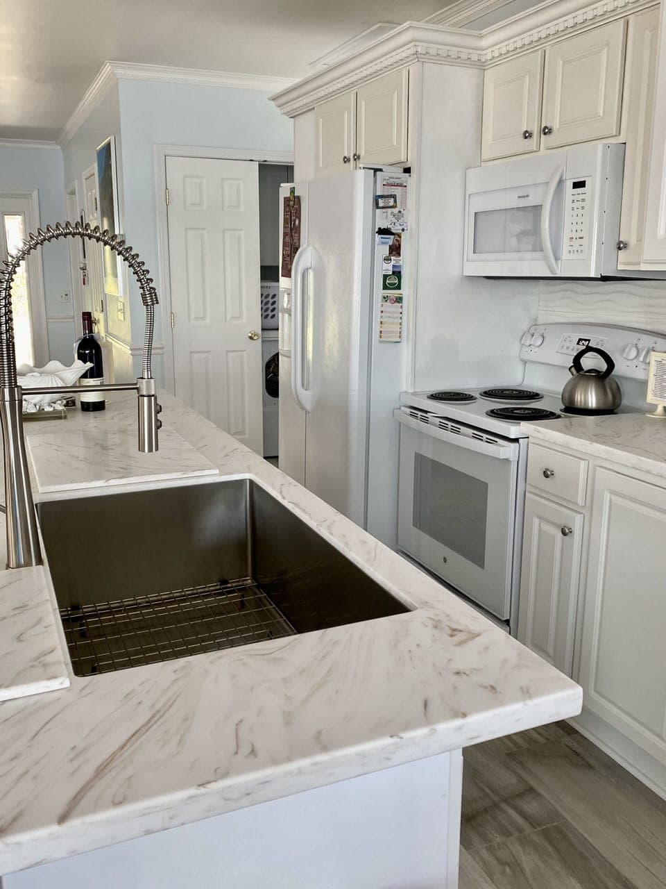 Kitchen with large stainless steel sink, refrigerator/ice maker, laundry closet