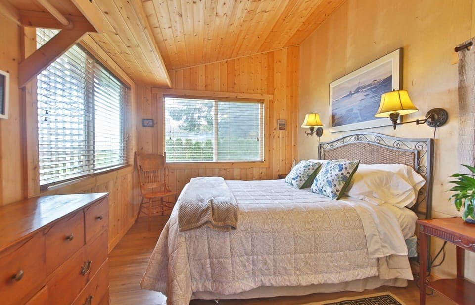 Bedroom with high ceilings and large widows with views to the beach.