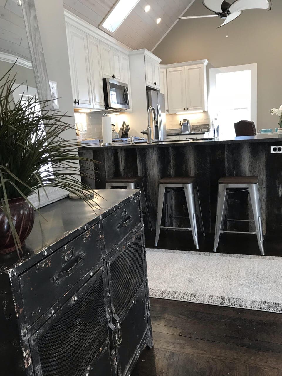 View into the kitchen from living room with barn wood   framed bar