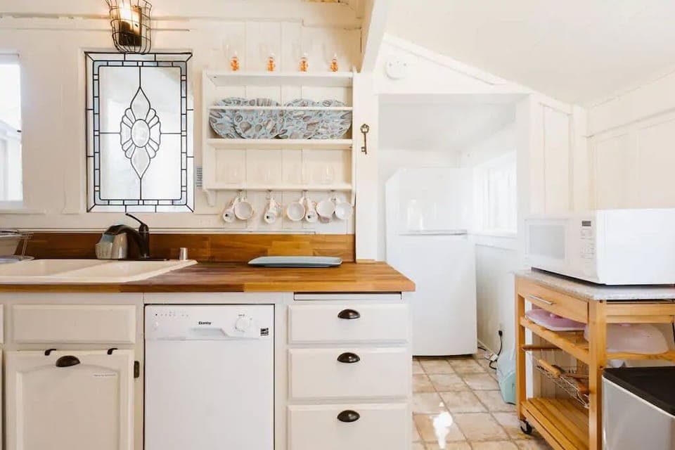 Retro-style kitchen with dishwasher, microwave, fridge.