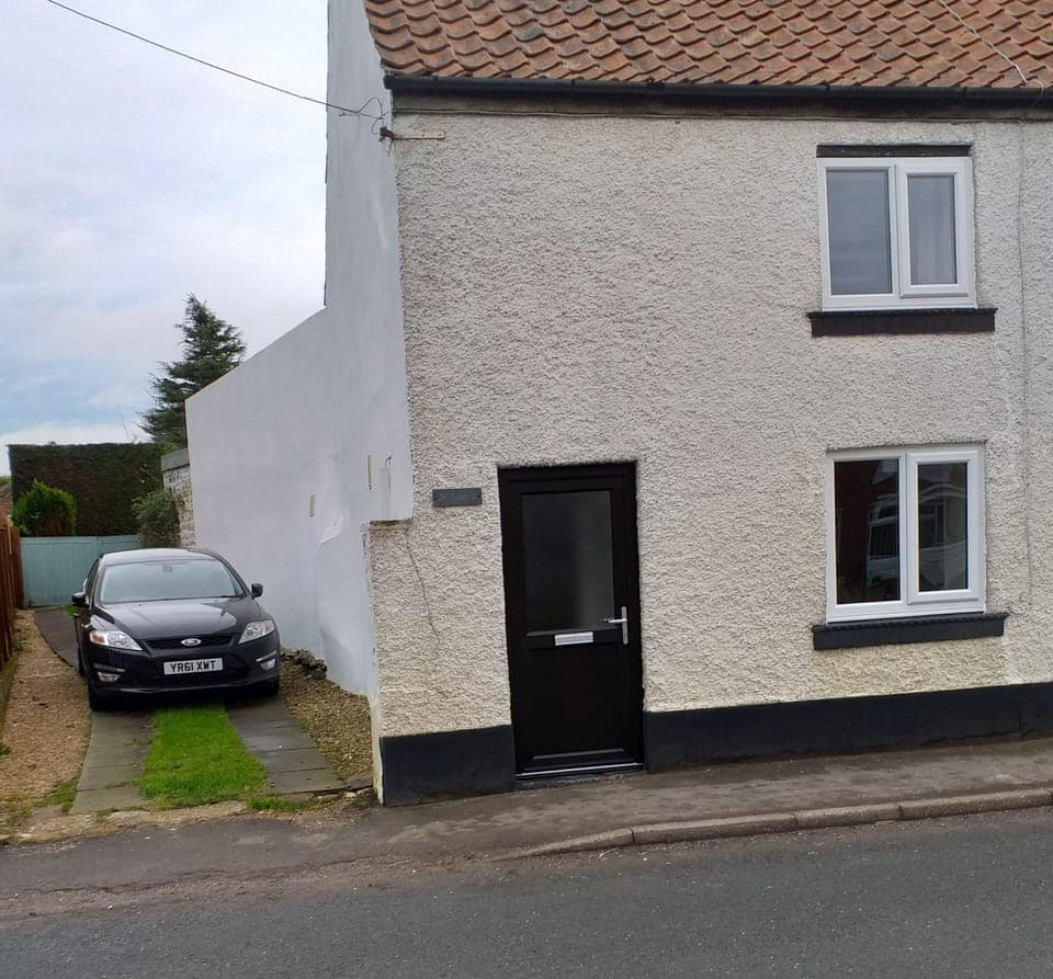 Front of the cottage, showing driveway parking.