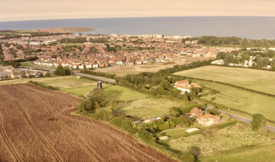 Mill Farm is the white buildings to the right of the black windmill 