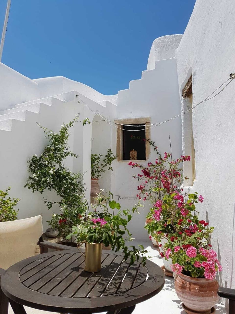 Sun trap roof terrace filled with flowers, with comfortable seating for relaxing