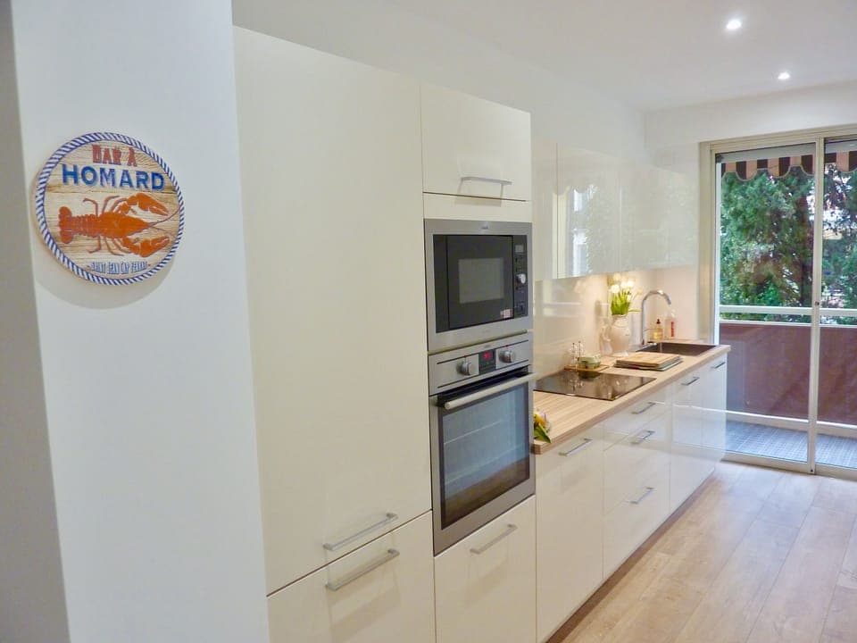 Bright and fully equipped kitchen with dishwasher and washing machine.