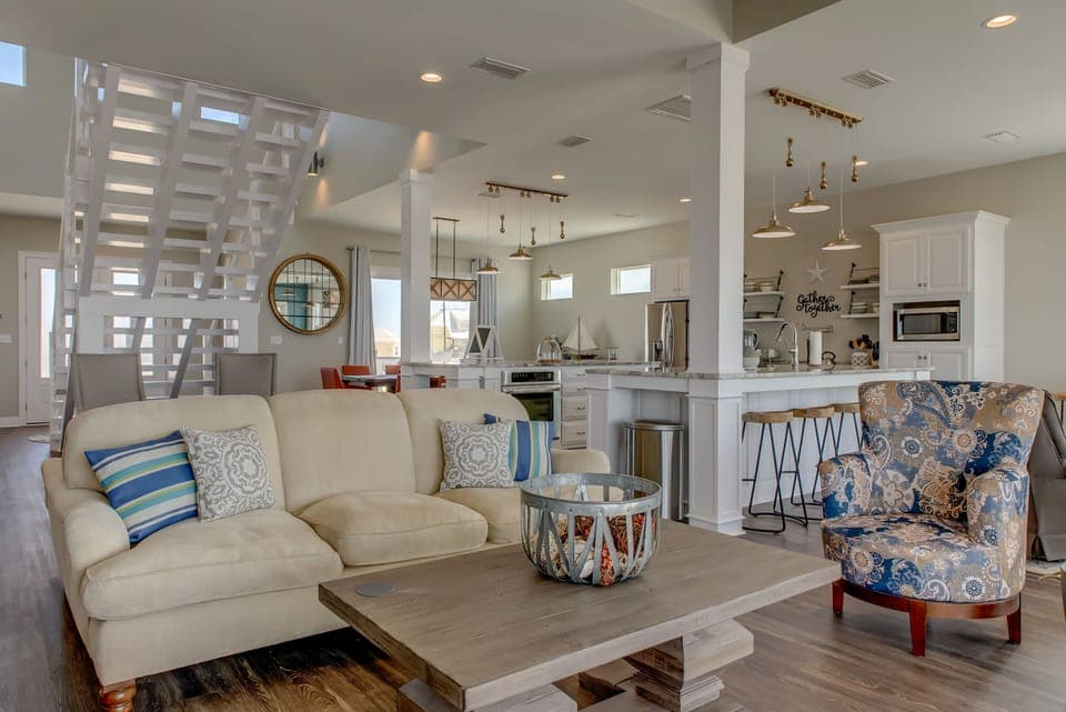 Unwind in your stylish open-plan living space where coastal charm meets modern comfort, complete with gourmet kitchen and cozy seating.