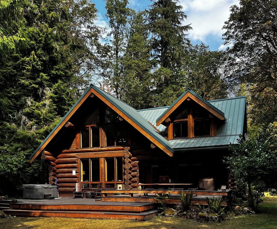 An exclusive hand crafted log cabin on the river surrounded by forest.
