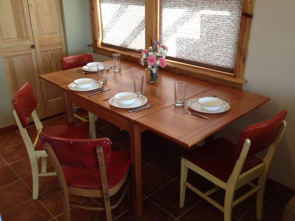 Dining room table with leaves pulled out for more spacious dining.