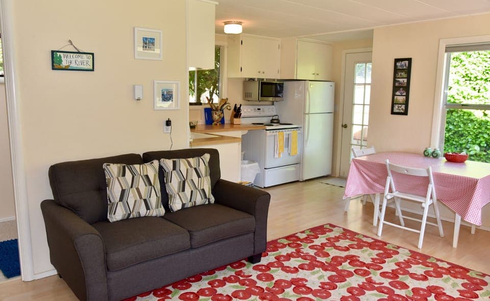 The living room flows into the well-equipped kitchen with a cozy dining area