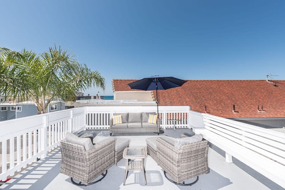 Exclusive rooftop deck with panoramic views includes ample seating.
                
