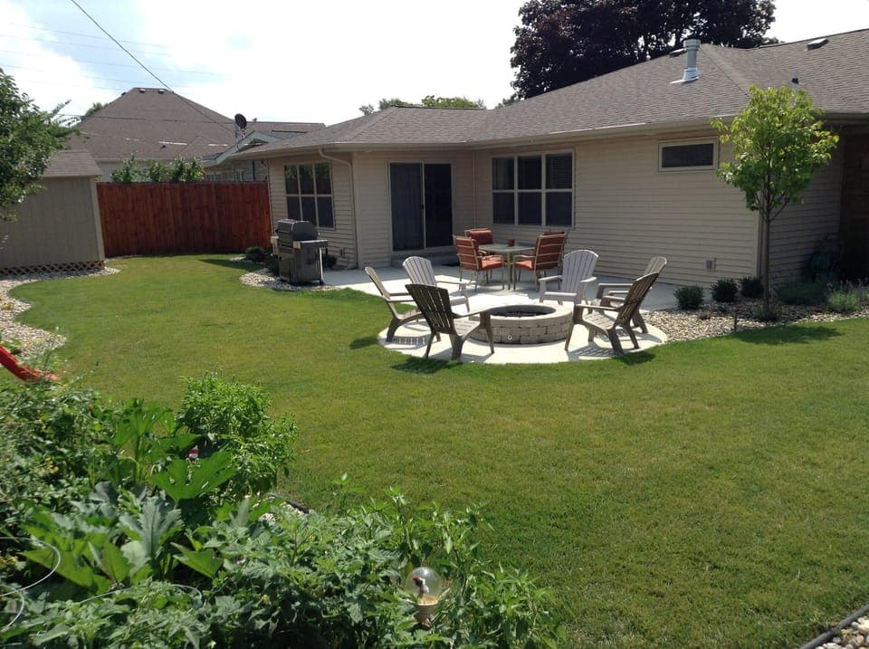 Backyard with in ground gas grill and gas fire pit. 