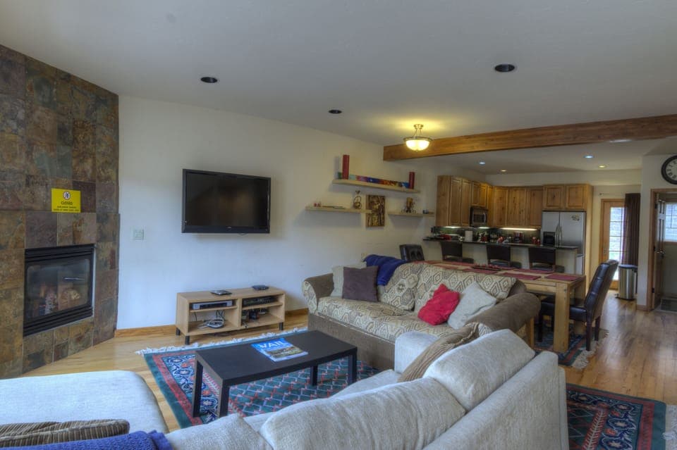 Middle floor contains kitchen, dining table, and living room.