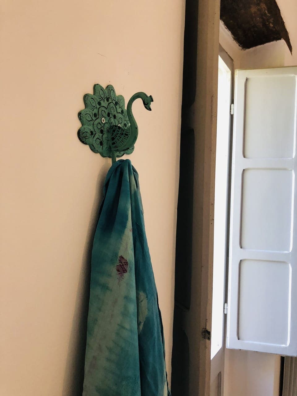 Peacock hook next to shutters leading to balcony  front bedroom 
