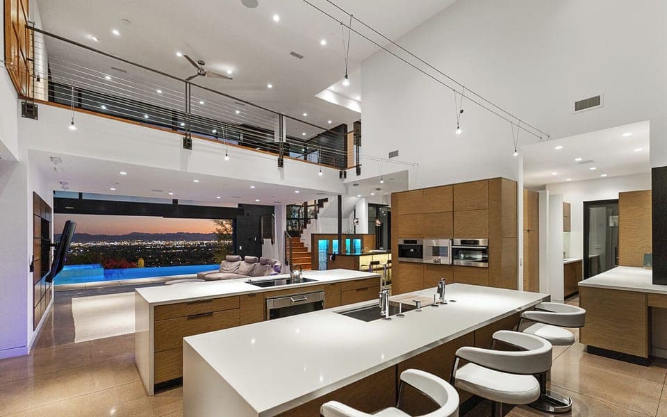 Sleek kitchen with spacious island, built-in appliances & patio access.
