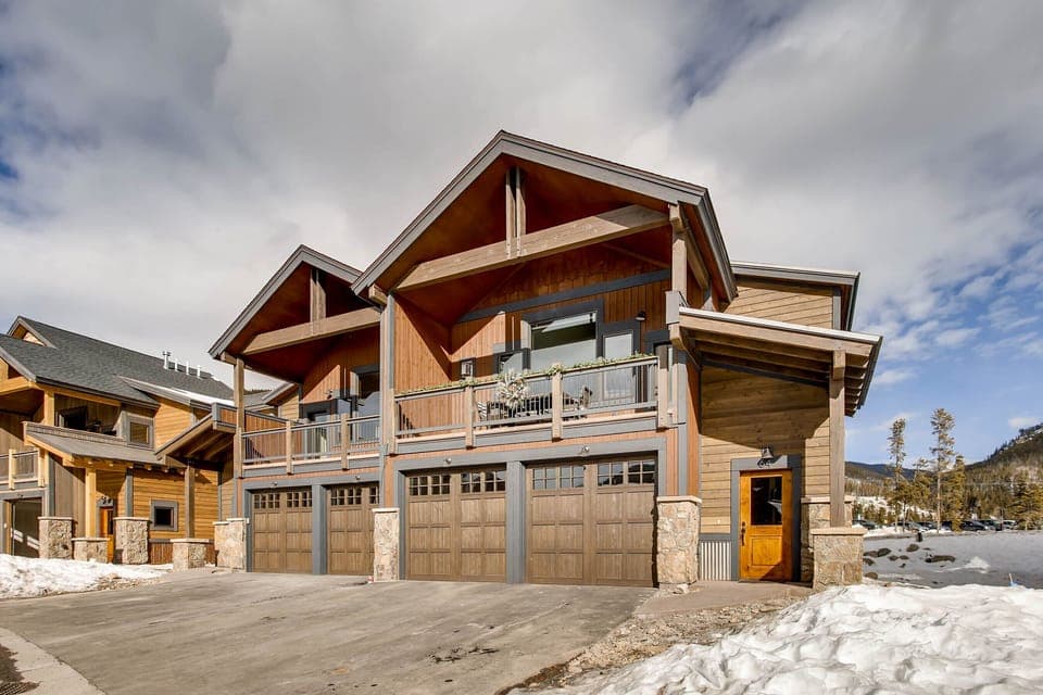 Front view showing the large covered deck and two heated garages.