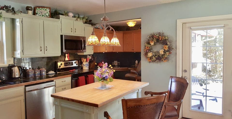 Fabulous kitchen with butcher block island and french doors leading to patio 