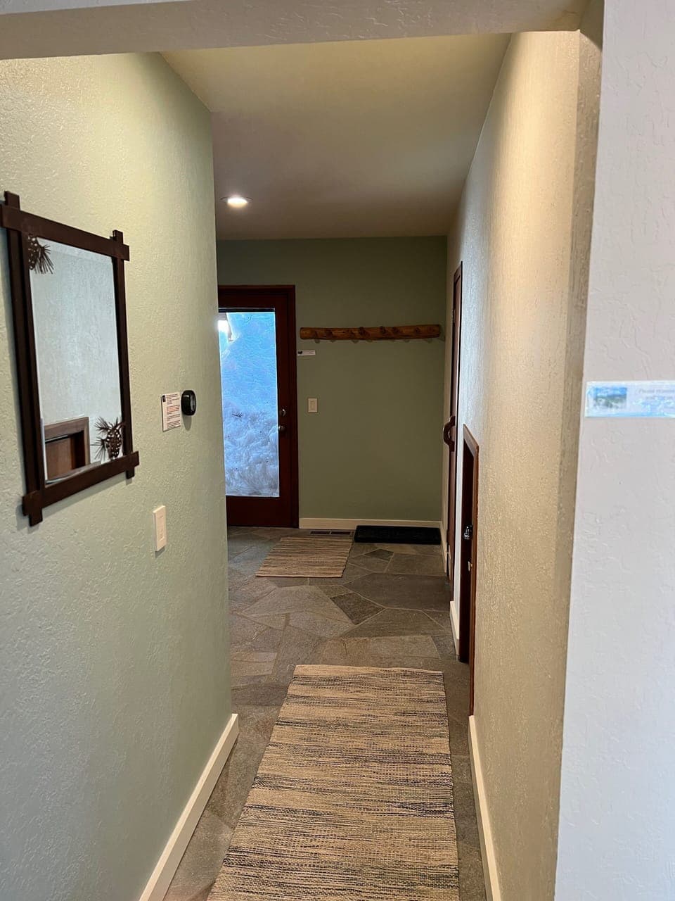 Descend the steps from primary to the entry-level hallway. New flagstone floor!