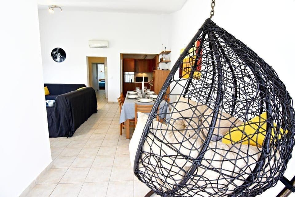 The living area with the suspended rocking chair, air conditioner