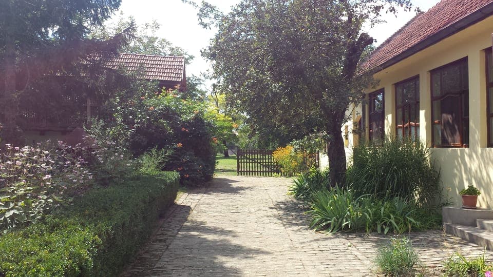 Open the gates and you see the house on right, garden left, and farmyard ahead.