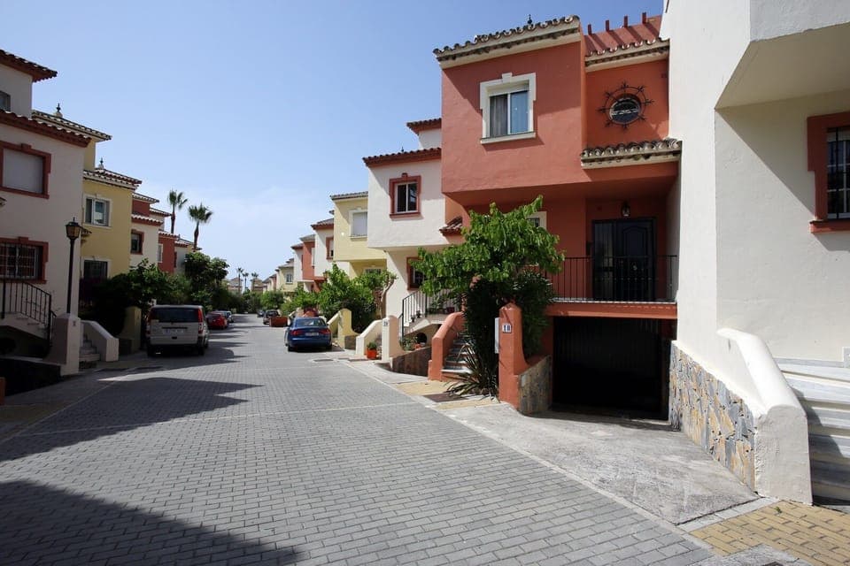 House (red) from outside. 200m down this quiet road you will find the beach!