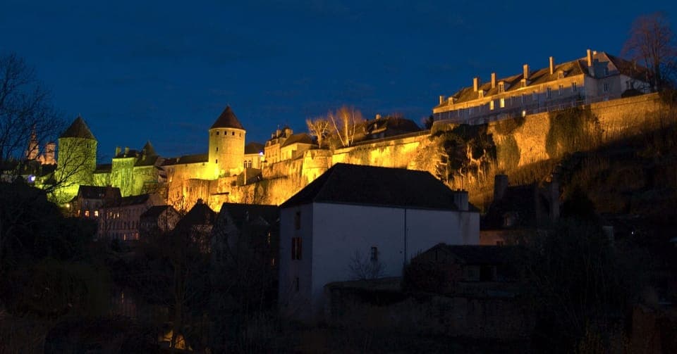 Semur-en-Auxois in early evening with the rampart walls lit up each night.