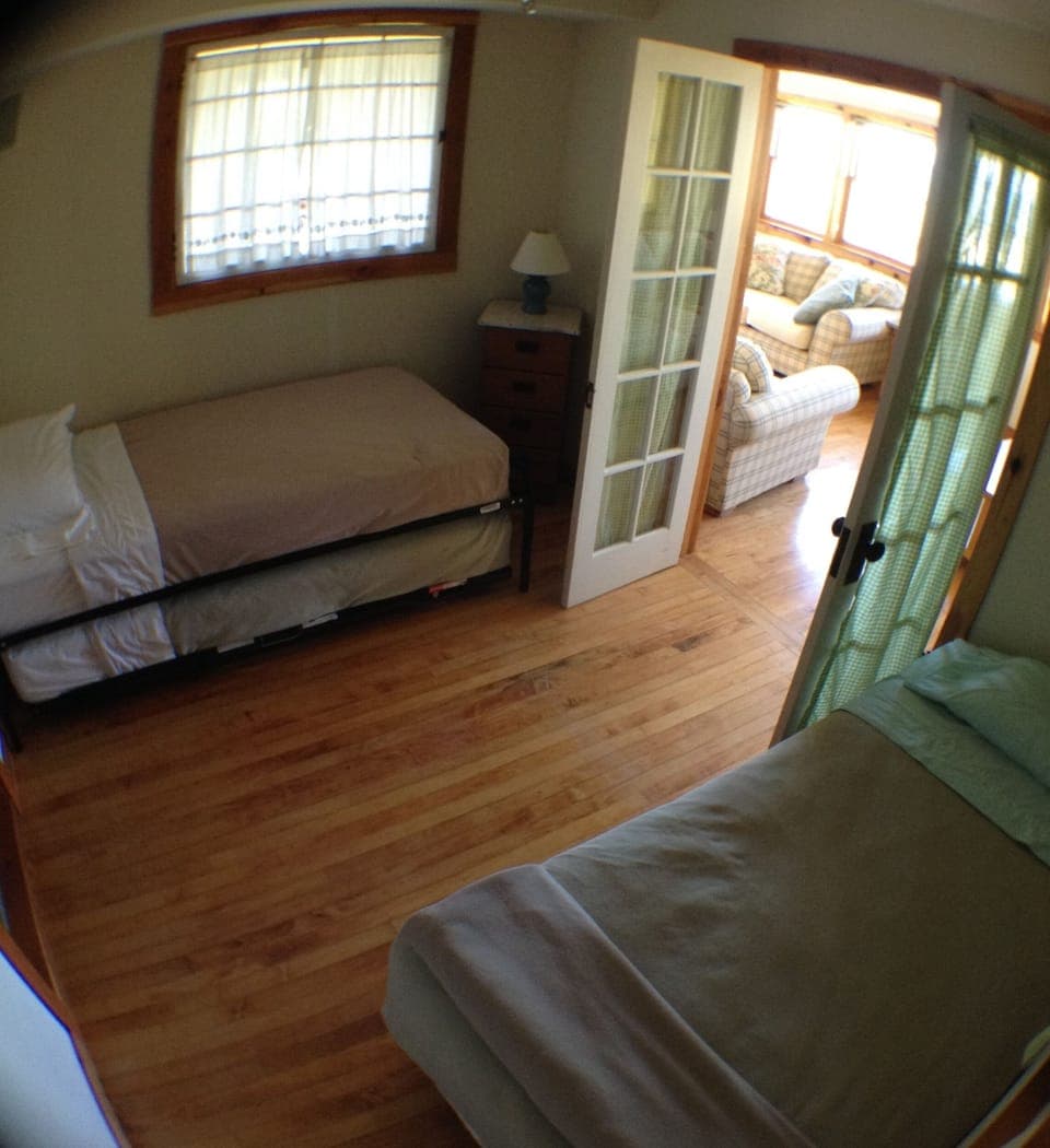 2nd bedroom with 2 twin beds and a trundle bed a 2 small dressers.