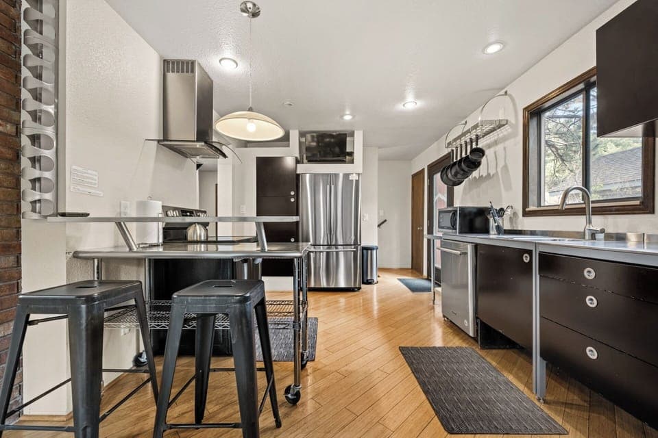 Fully stocked kitchen with stainless countertops, appliances, spices, dishware