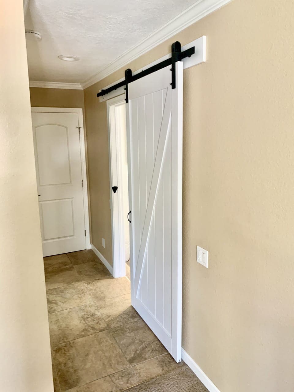 Sliding barn door for added space and privacy in the master bathroom