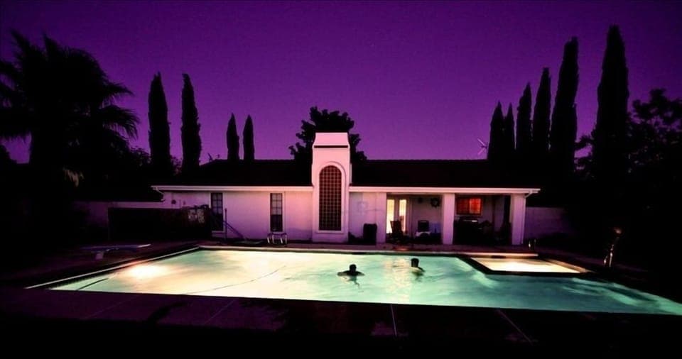 Guests enjoying the pool at night.