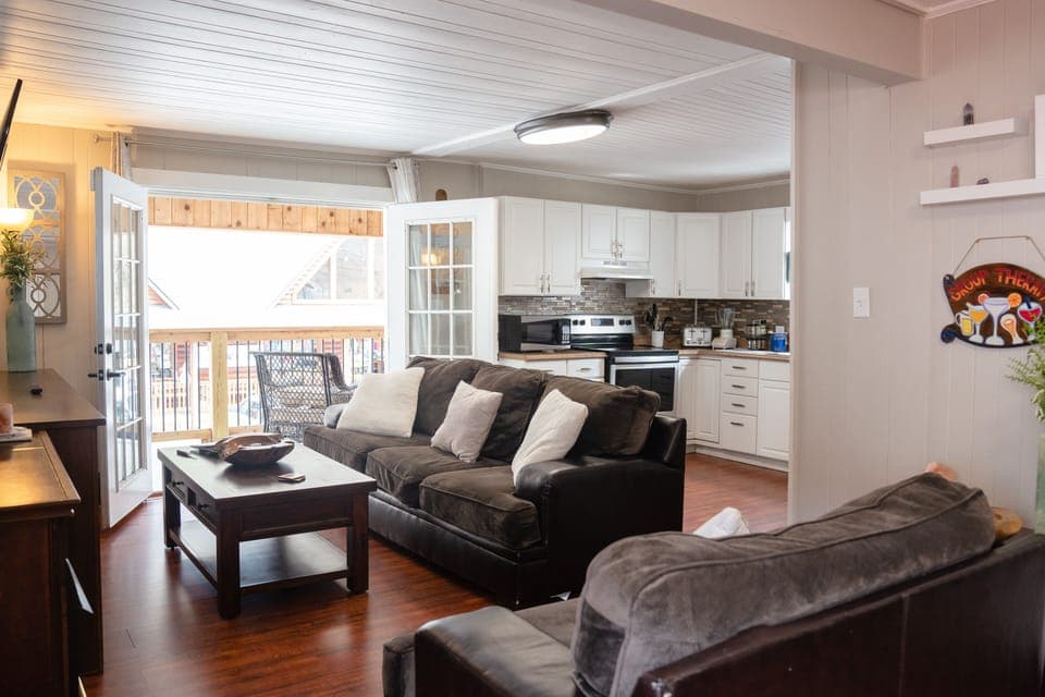 Living room features two couches, coffee table, and brand new 65-inch smart TV