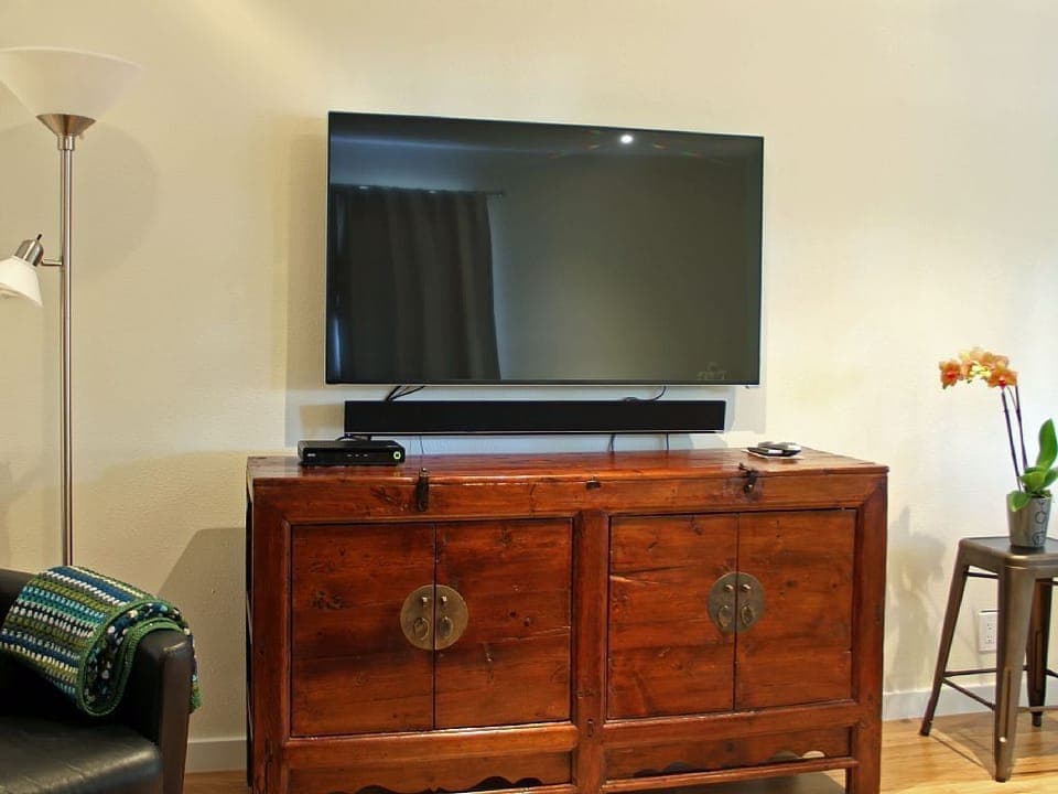 55 inch TV with surround sound bar in living room.