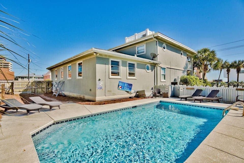 Sparkling private pool framed by palm trees and coastal charm.