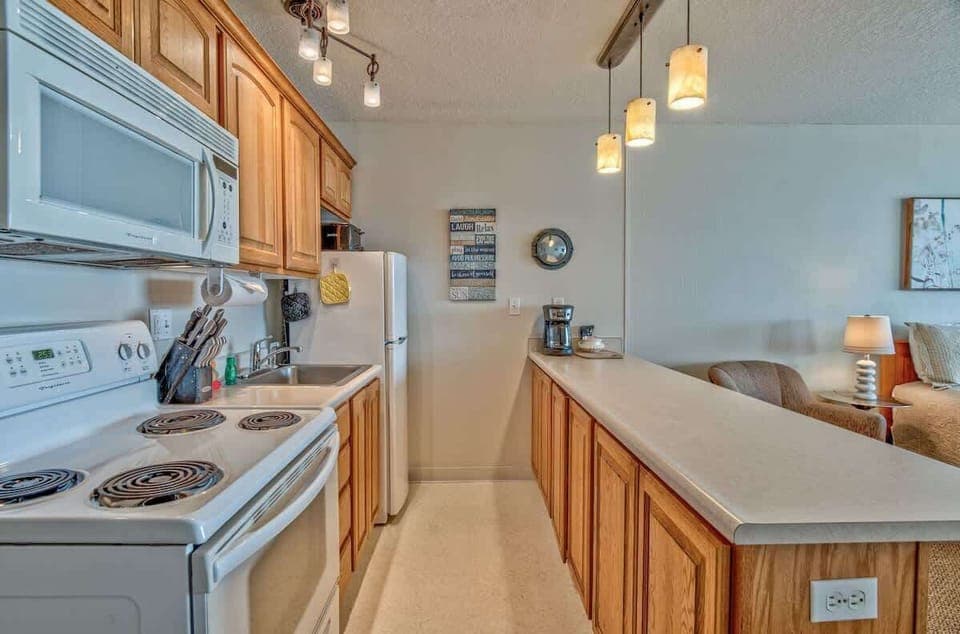 The kitchen has a stove, oven, microwave, and fridge