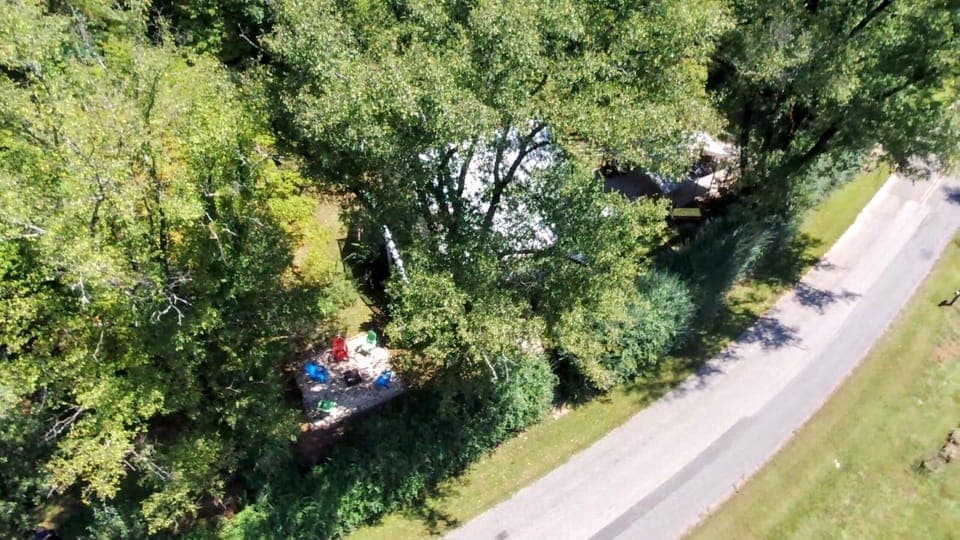 Paved road that leads to cabin with paved, covered parking and driveway