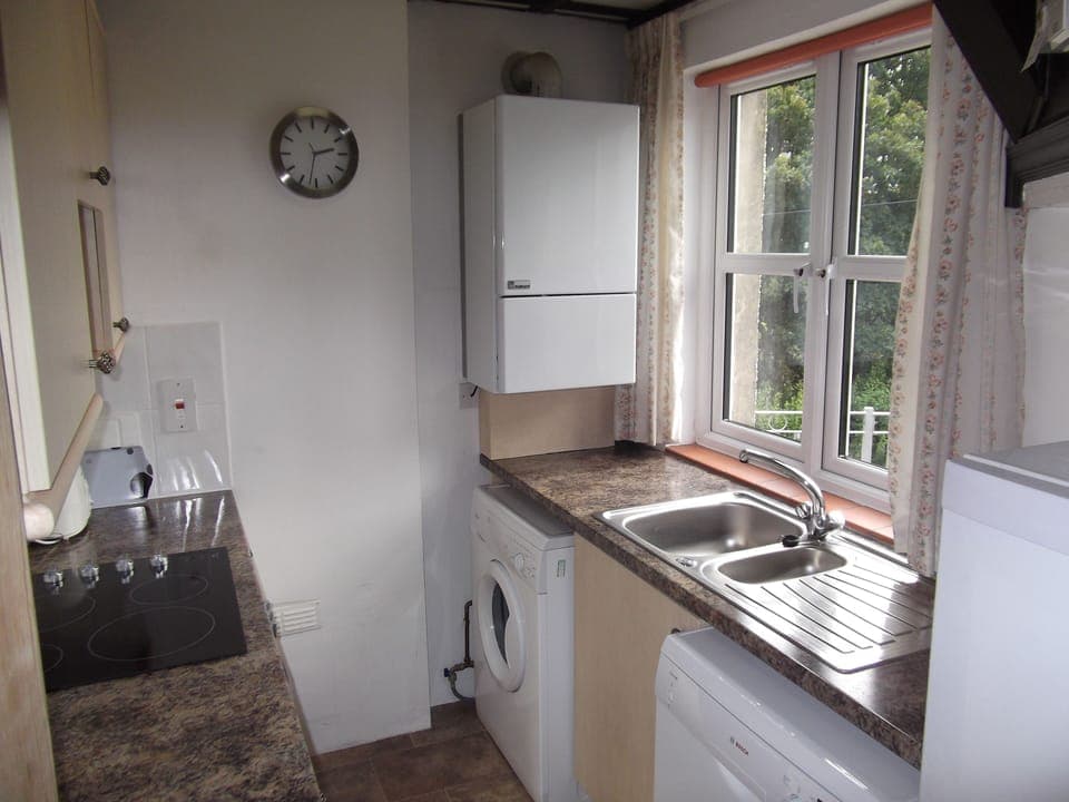 The kitchen with ceramic hob, oven, dishwasher, washing machine, fridge/freezer