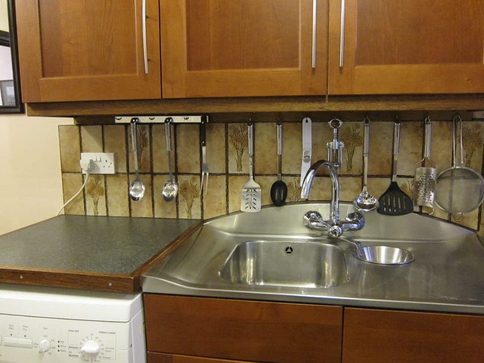 Stainless steel sink with mixer tap.  Washer under adjoining work top