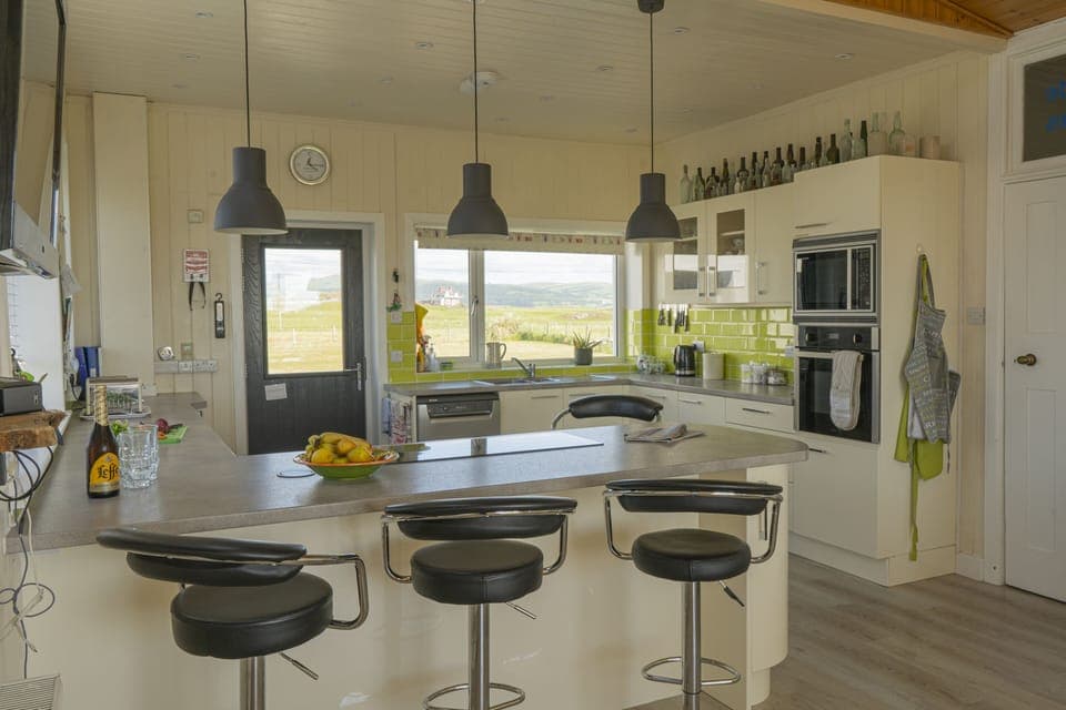 Breakfast bar houses induction hob. 4 Adjustable bar stools for informal dining