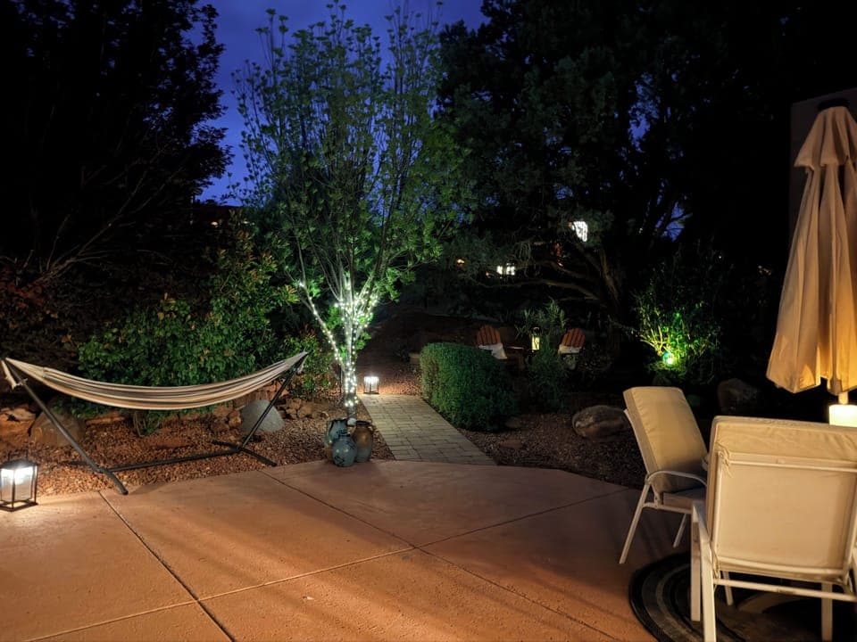 Unwind under the lights—hammock, Adirondack seating, and outdoor dining