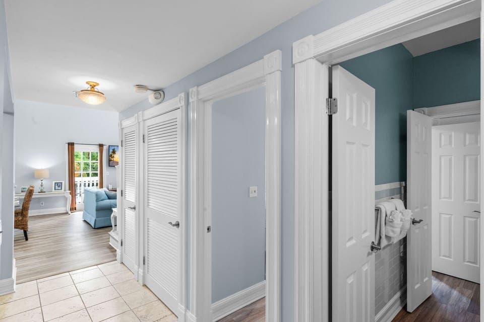 Hallway from front door to living area. Bath and queen bedroom doors on right. 