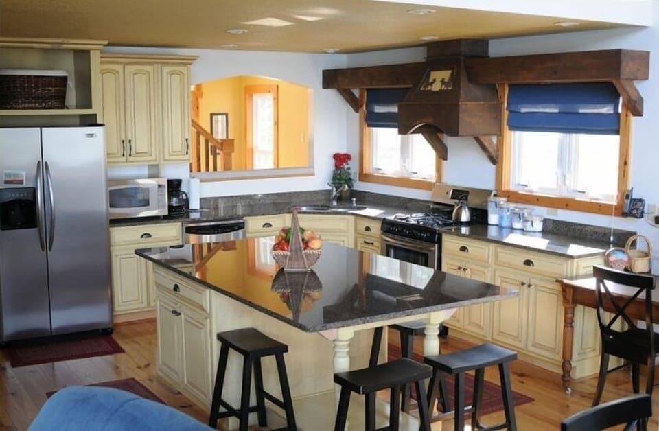 View of kitchen including island, refrigerator, microwave, dishwasher, stove